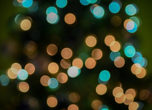 Colorful bokeh lights in blue and gold against a dark background.